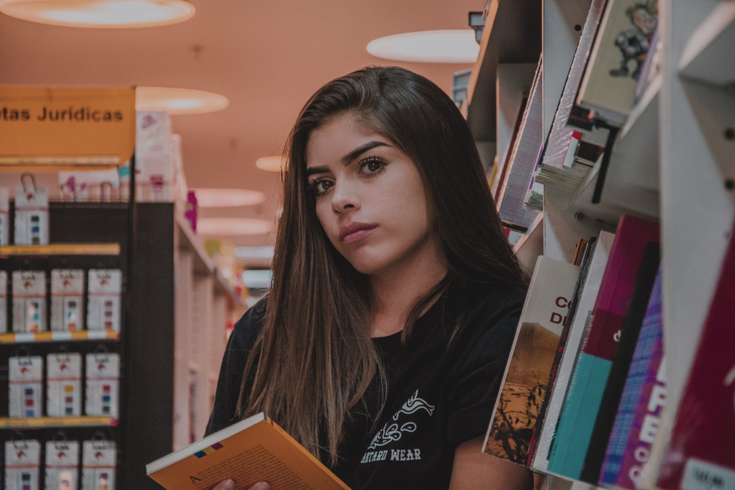 woman-in-black-top-leaning-by-bookcase-2393793